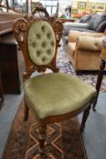 A Victorian carved walnut and button upholstered occasional chair.