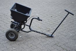 A twin wheeled garden lawn seed spreader.