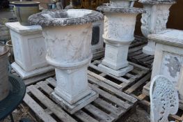 A pair of carved white marble classical style urns on pedestal bases.