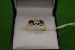 An 18ct gold diamond and ruby three stone ring size M½.