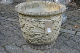 A composite garden planter with moulded acorn and oak leaf decoration.