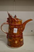 A Chinese pottery ewer, red glazed with gilded decoration.