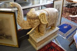 A large Chinese carved segmented bone model of an elephant on a pedestal base, 110cm long x 110cm