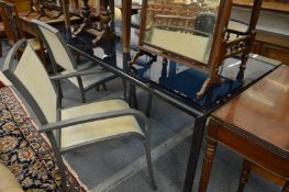 A stylish glass top rectangular dining table with four aluminium chairs.
