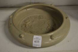 A Chinese celadon glazed moulded circular brush washer.