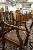 A set of eight mahogany dining chairs, two with arms, all with leather upholstered drop in seats.