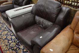 A pair of brown leather upholstered armchairs.