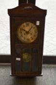 An oak cased wall clock.