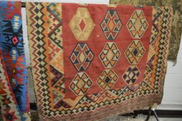 A flat weave Kilim carpet, red ground with stylised decoration 240cm x 146cm.