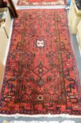 A Persian design carpet, crimson ground with a central medallion 190cm x 100cm.