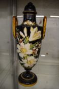 A floral painted twin handled vase and cover.