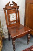 A Victorian mahogany hall chair with tile inset back.