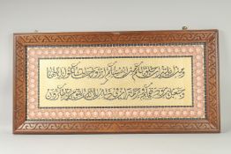 A LARGE ISLAMIC MOSAIC STYLE CALLIGRAPHIC PANEL, inset within a carved wood frame, 49cm x 100cm
