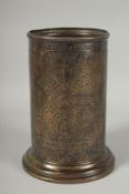 A QAJAR MARKET EUROPEAN 'KINCO' ENGRAVED BRASS CYLINDRICAL POT, 19.5cm high.