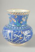 AN OTTOMAN TURKISH IZNIK GLAZED POTTERY VASE, with calligraphy, 21cm high.