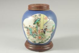 AN EARLY 20TH CENTURY CHINESE BLUE GROUND FAMILLE VERTE PORCELAIN JAR, with wooden cover and stand.