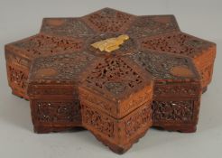 A FINE 19TH CENTURY PERSIAN QAJAR ABADEH CARVED WOOD STAR-SHAPE BOX, the lid with carved and pierced