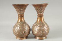 A PAIR OF MAMLUK SILVER INLAID COPPER VASES, with engraved and chased decoration, 25cm high.