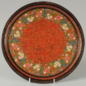 A KASHMIRI LACQUERED CIRCULAR DISH, with floral decoration and gilt highlights, 31cm diameter.