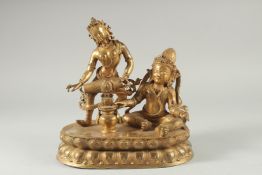 A LARGE GILT BRONZE FIGURE OF TWO DEITIES ON AN OVAL DOUBLE-LOTUS BASE, 28cm wide.