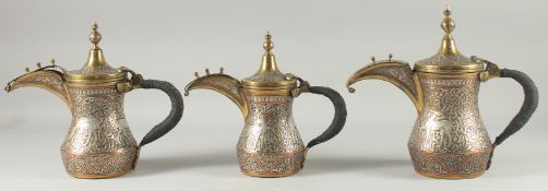 A FINE SET OF THREE EARLY 20TH CENTURY CAIROWARE ARAB SILVER AND COPPER INLAID BRASS COFFEE POTS