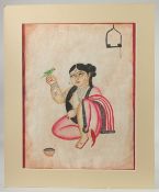 KALIGHAT SCHOOL BENGAL PAINTING ON PAPER OF A LADY WITH BIRD, with mount and mount board surround;