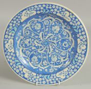 A TURKISH KUTAHYA GLAZED POTTERY PLATE, painted with interlocking foliate design, 32cm diameter.