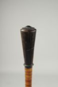 A RHINO HORN HANDLED CANE with a turned handle and segmented horn shaft.