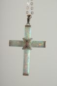 AN OPAL CROSS on a silver chain.