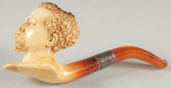 A MEERSCHAUM PIPE carved as a Negro head. 7cm long 6cm deep with silver band and amber mouthpiece,