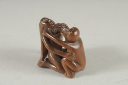A CARVED WOOD EROTIC NETUKE. Signed. 1.5ins.