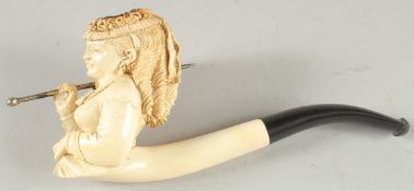 A MEERSHAUM PIPE CARVED AS A YOUNG LADY carrying a parasol. 9cm long, 7cm deep, with amber