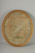 A REGENCY SILKWORK OVAL GILT FRAMED PICTURE of a pheasant in a tree. 19ins x 16ins.