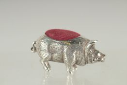 A NOVELTY SILVER PIG PIN CUSHION. 1.5ins long.