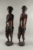 A LARGE PAIR OF CARVED HARDWOOD AFRICAN FIGURES OF MEN. 35ins high.