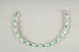 A SILVER AND EMERALD LINE BRACELET.