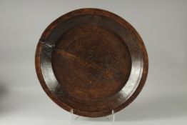 A LARGE EARLY TREEN CIRCULAR PLATTER. 22ins diameter.
