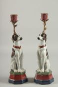 A PAIR OF PORCELAIN DOG CANDLESTICKS. 13ins high.