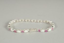 A SILVER RUBY AND OPAL LINE BRACELET.