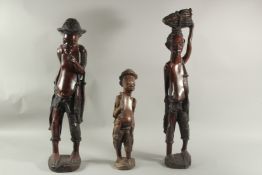 THREE AFRICAN CARVED HARDWOOD FIGURES, a man, a woman and a boy. 27ins (2) 7 15ins.