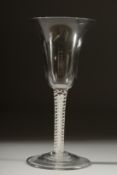 A GEORGIAN WINE GLASS with inverted bell shape bowl and white twist stem. 6ins high.
