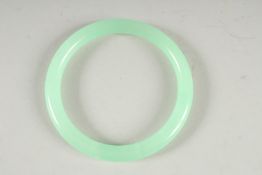AN ICY JADE BANGLE. 3ins diameter.