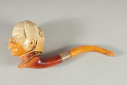 A MEERSCHAUM PIPE CARVED AS AN EGYPTIAN HEAD. 9cm long, 8cm deep with curving amber mouth piece in a