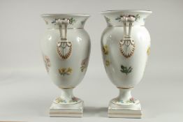 A GOOD PAIR OF SEVRES DESIGN WHITE GROUND PORCELAIN TWO HANDLED VASES painted with birds on square