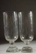 A PAIR OF STAR CUT GLASS STORM LAMPS on square bases. 15ins high.