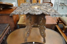 A Chinese carved wood occasional table with folding base.