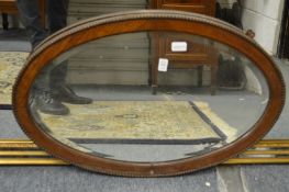 An oval framed mirror.