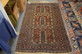 A modern Persian style carpet, rust ground with three central panels, 200cm x 120cm.