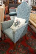 An upholstered high back armchair.