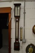 A Negretti & Zambra oak cased stick barometer together with another thermometer gauge.